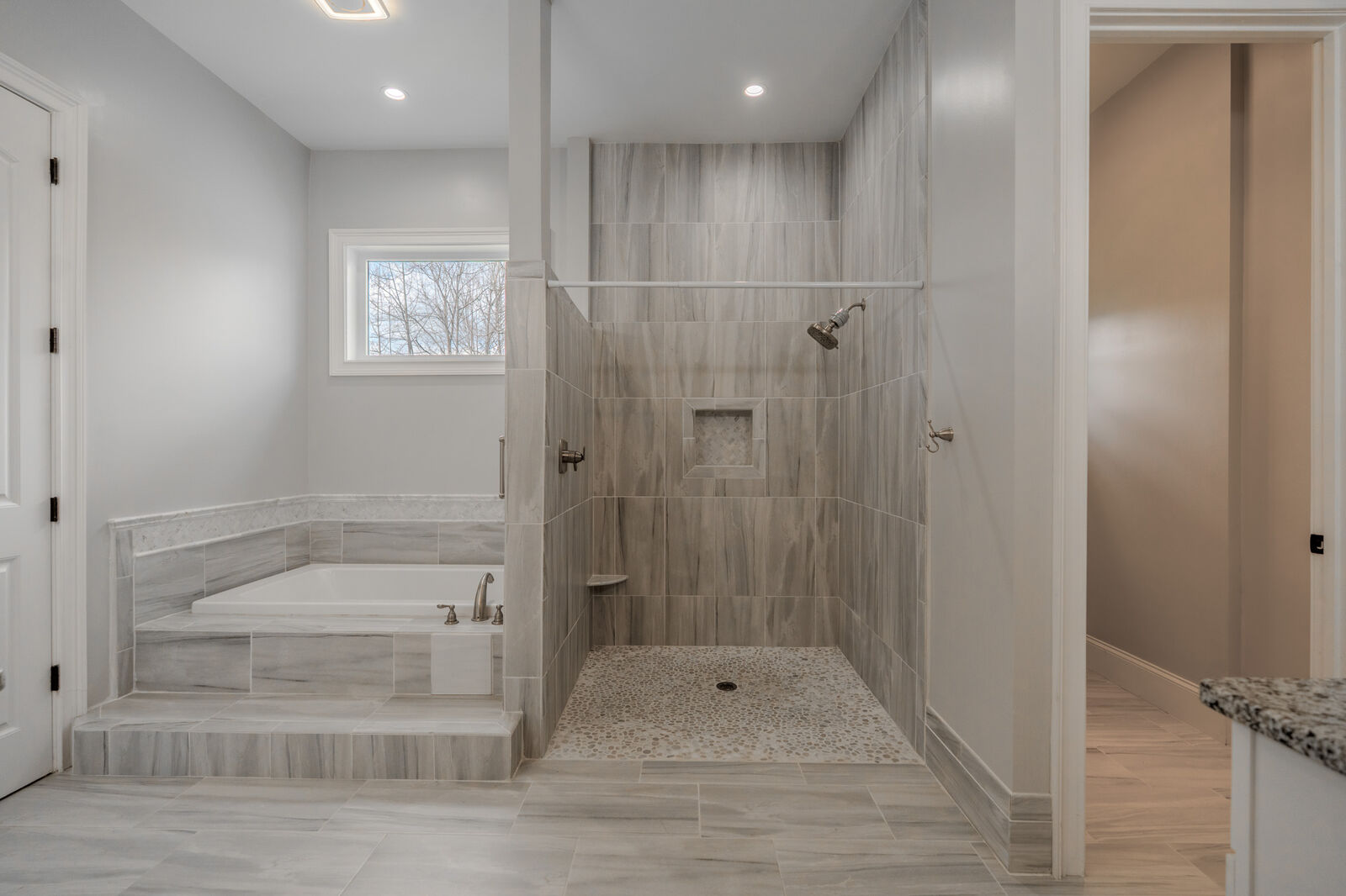 Primary bath with a soaking tub and a tiled walk-in shower
